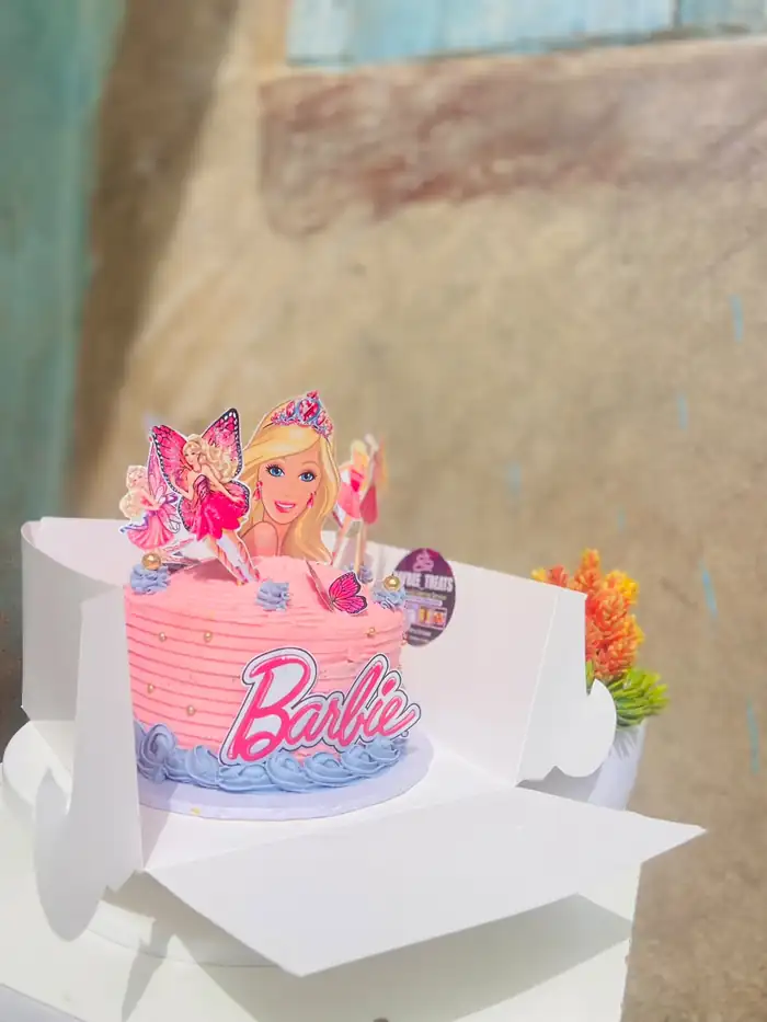 Pink Barbie character birthday cake with topper