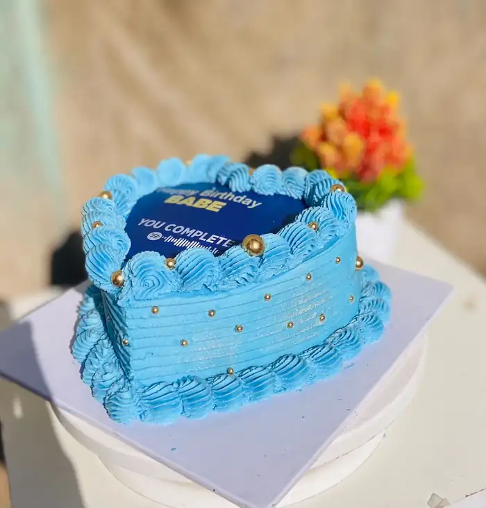 Blue heart-shaped birthday cake with piped shell border
