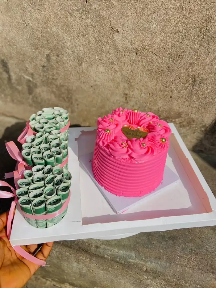 Money stack roll beside a pink mini cake